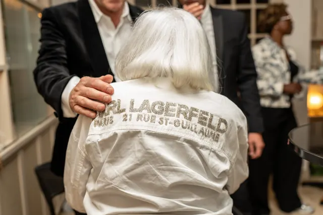 Mémé de costas, com a sua camisa branca Karl Lagerfeld, abraçada por um convidado